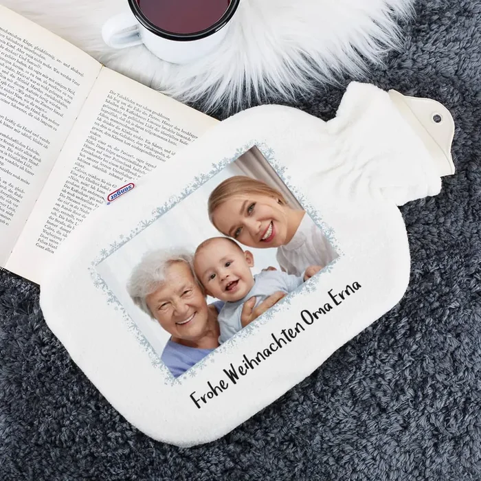 Weiße Wärmflasche mit Fotoaufdruck und Schneeflockenrahmen